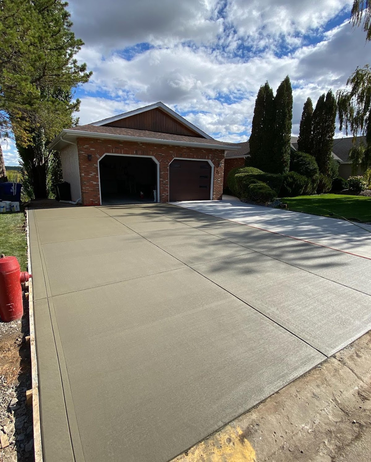 A newly poured concrete driveway running from the street up to a two-car garage.